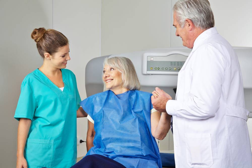 Doctor and MTA helping senior woman in radiology at bone density measurement