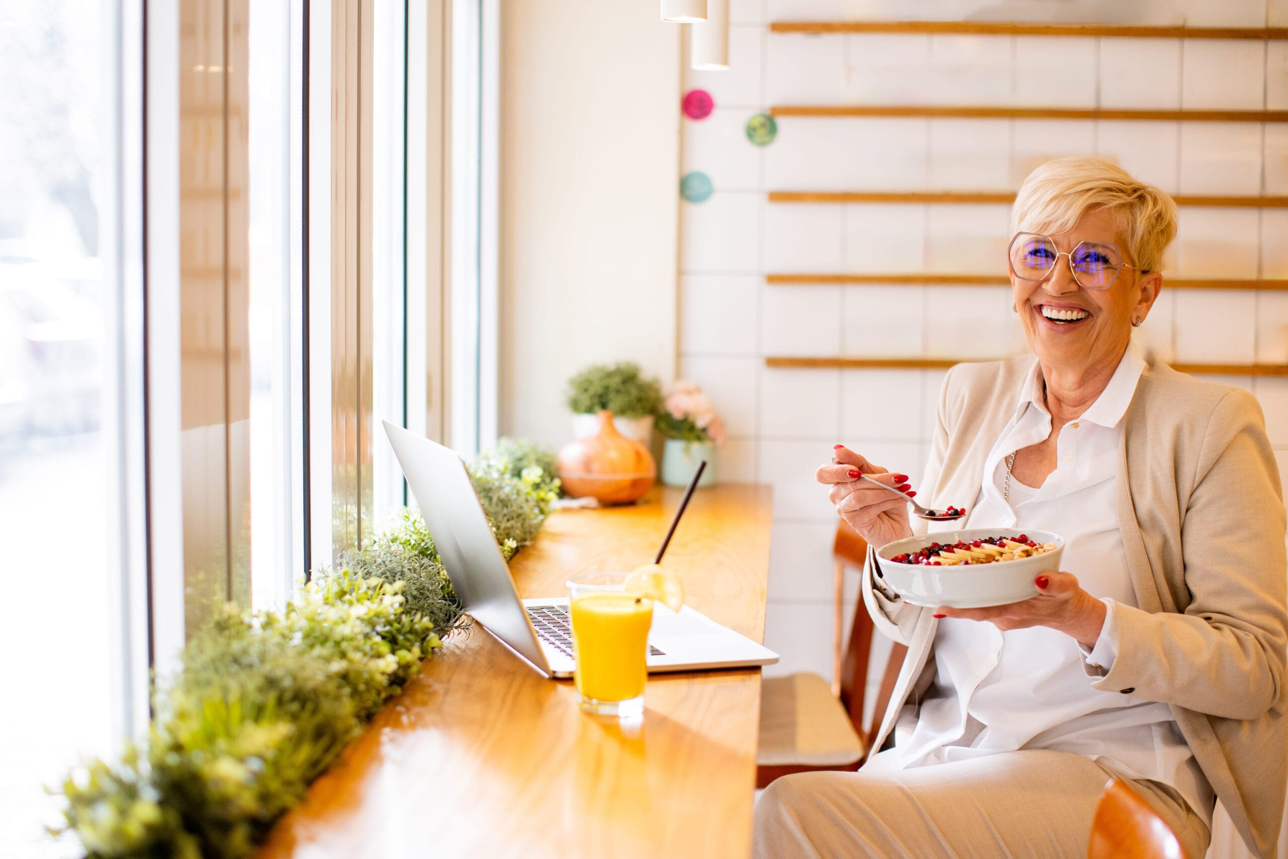 Smiling older woman eating a healthy breakfast bowl