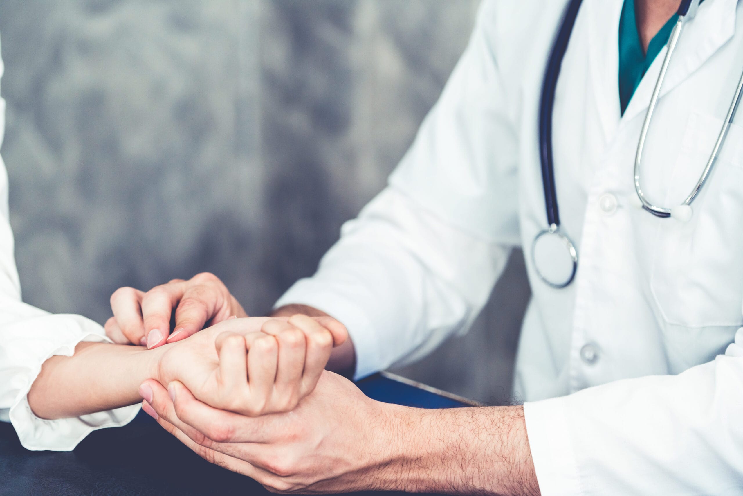 Doctor gently examining a patient's hand and wrist